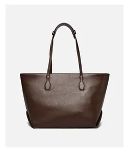 Close-up of a dark brown tote bag showing smooth leather texture and refined stitching