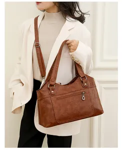 Sac à main marron en similicuir porté avec veste blanche pour un style chic urbain