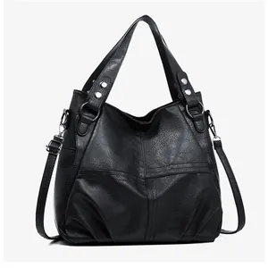 Detail of black pebbled leather tote featuring geometric stitching and silver hardware