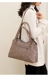 Gros plan sur la texture du cuir synthétique taupe et les détails de la fermeture