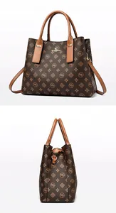 Vue détaillée du sac à main monogramme avec ferrures dorées et poignée en cuir