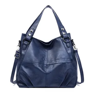 Retro deep blue leather tote bag with cross-stitch design and adjustable shoulder strap