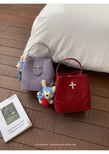 Detail of retro bucket bags with silver cross locks and cute teddy bear charms