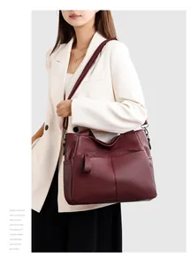 Dettaglio della borsa tote in pelle bordeaux con grana litchi indossata da modella