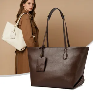 Minimalist soft leather tote bags in cream and dark brown with a subtle lychee texture