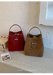 Detail of retro bucket bags in red and brown with metal twist-locks and drawstring liners