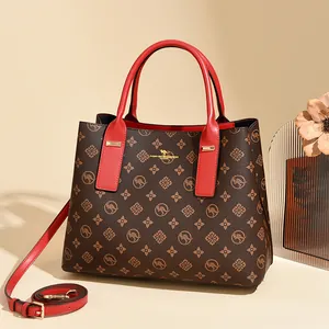 Sac à bandoulière marron à monogramme classique avec poignées rouges et détails dorés