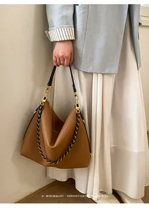 Detailed view of brown lychee grain leather tote bag with gold chain and leather straps