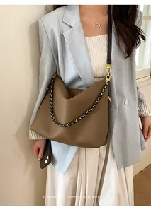 Detail of coffee brown litchi leather hobo bag with gold chain and dual strap options