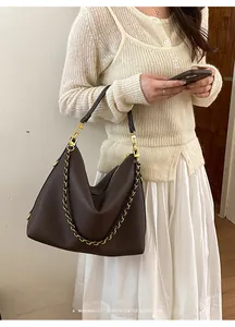 Close-up of a large coffee brown litchi pattern leather tote bag with gold chain strap