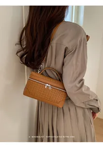 Détail du sac à main tissé marron avec fermeture éclair argentée et style rétro chic