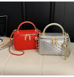 Detail of red and silver beaded box bags with gold chain straps and metal handles