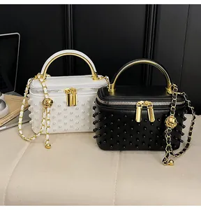 Detail of luxury vanity bags with pearl embellishments and gold chain shoulder straps