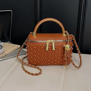 Brown box handbag with pearl embellishments and metallic gold top handle and chain strap