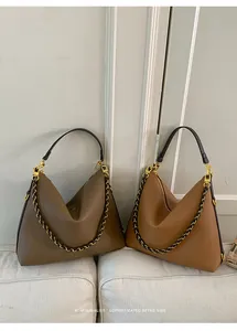 Detail of large leather hobo bags with woven chain accents in brown and tan
