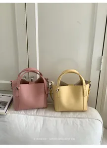 Close-up of pink and yellow lychee texture leather bucket bags with metal hardware