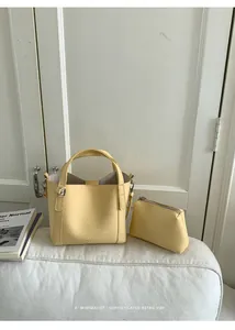 Detail view of light yellow litchi grain leather bucket bag set with matching pouch