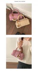 Mini Boston bag detail showing lychee texture, top zipper, and horse charm in pink and beige