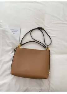 Detail of soft leather brown tote bag with adjustable strap and golden metal hardware