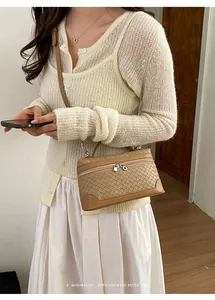 Détail d'un sac bandoulière tissé marron clair avec ferrures argentées et style rétro