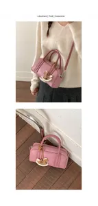 Detail view of pink leather Boston bag with horse charm and adjustable strap