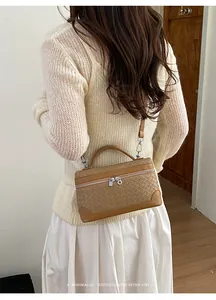 Détails de la texture tissée marron sur le sac boîte rétro avec fermeture éclair argentée