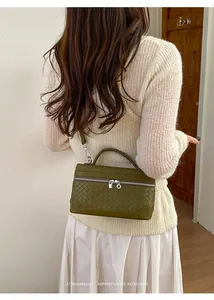 Détail du sac bandoulière en cuir tressé vert olive foncé avec fermeture éclair argentée