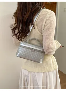 Détail du sac à bandoulière tressé argenté au design de boîte rétro et minimaliste