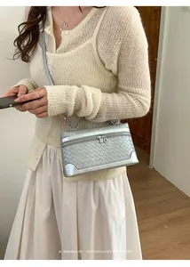 Détail de la texture en cuir tressé argenté et des coins métalliques du petit sac