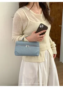 Détail d'un sac à main en cuir tressé bleu clair avec fermetures éclair et poignée chic