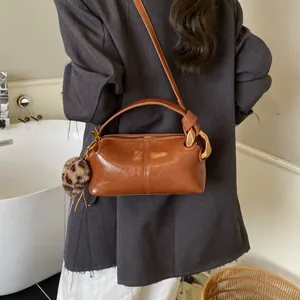 Vintage brown leather pillow bag with knot handle and leopard print keychain