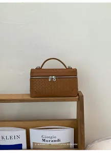 Gros plan sur la texture tressée marron et la fermeture éclair argentée du sac carré