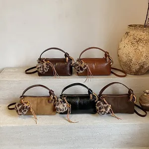 Vintage brown leather cylinder pillow bag in five earthy tones with leopard heart charm