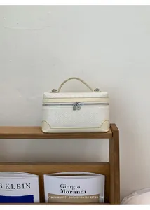 Détail d'un sac à main en cuir tressé blanc avec poignée supérieure et base renforcée