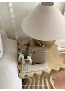 Détail du petit sac bandoulière en cuir kaki avec charm cheval sur table design