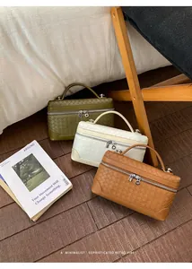 Détail de sacs à main tressés en vert olive, crème et caramel avec poignées supérieures