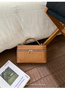 Vue de dessus d'un sac à main en cuir tressé marron avec design rétro et zips argentés