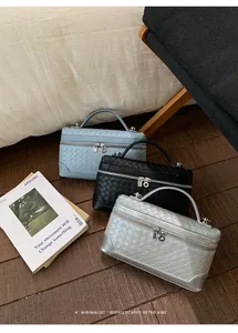 Détail de sacs tressés avec fermetures éclair circulaires en bleu, noir et gris argenté