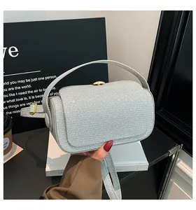 Vue détaillée du mini sac argenté pailleté avec fermoir doré et poignée supérieure