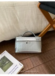 Détail d'un sac à main argenté avec texture tressée et finition métallique chic