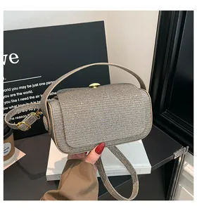 Détail d'une pochette rectangulaire scintillante avec fermoir doré et anse courte