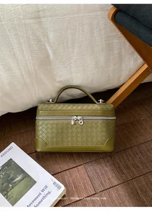 Détail du petit sac carré vert olive à texture tressée et fermeture éclair argentée