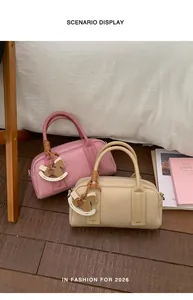 Detail of Boston bags featuring pink and beige crocodile patterns with wooden horse charms