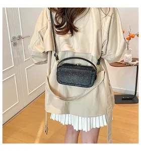 Vue arrière du mannequin portant un sac à bandoulière noir à paillettes et chaîne dorée