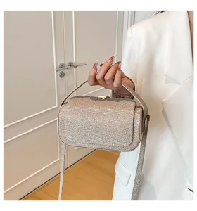 Gros plan d'un sac à main doré pailleté avec poignée et fine bandoulière élégante
