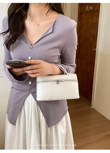 Détail du sac à main blanc en cuir grainé avec fermeture éclair argentée pour femme