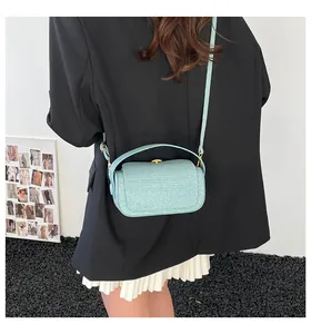 Vue portée d'un sac à main pailleté vert menthe avec fermoir et bandoulière