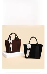 Detail of dark brown and black leather tote bags with elegant white fabric ribbons