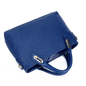 Bolso de mano azul oscuro con patrones ovalados grabados y detalles dorados