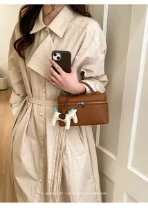 Sac à main en cuir grainé marron avec breloque poney et détails dorés